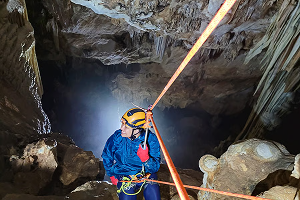 pessoa descendo de rapel dentro da caverna do diabo